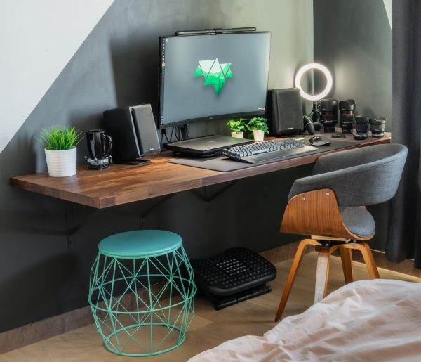 یک اتاق کوچک با میز کامپیوتر و یک طراحی ویژه و ساده