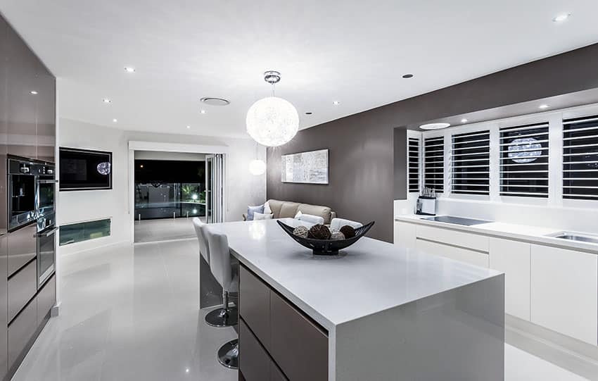 Modern dark hued kitchen with solid surface countertops