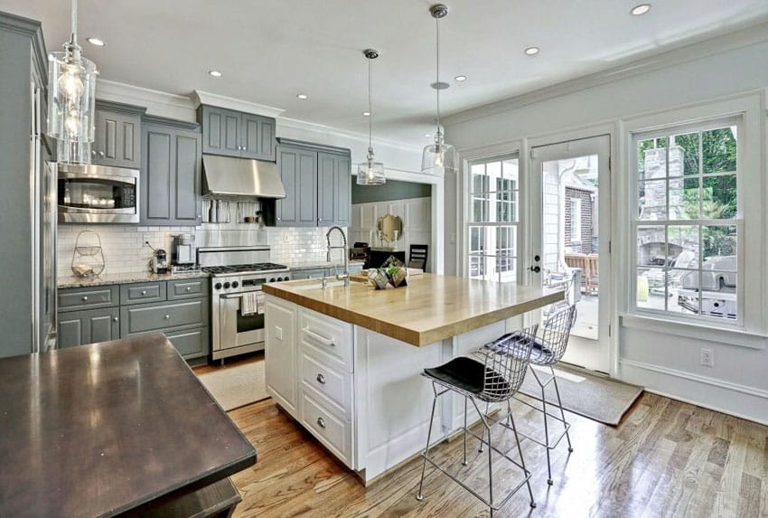 Traditional kitchen with two tone gray cabinetry, and white island